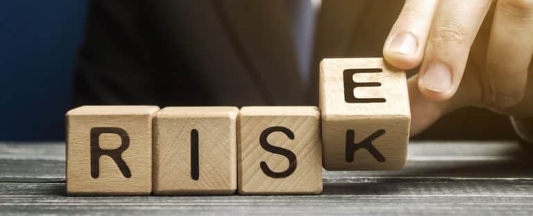 Wooden blocks spelling risk flipping k to e for rise