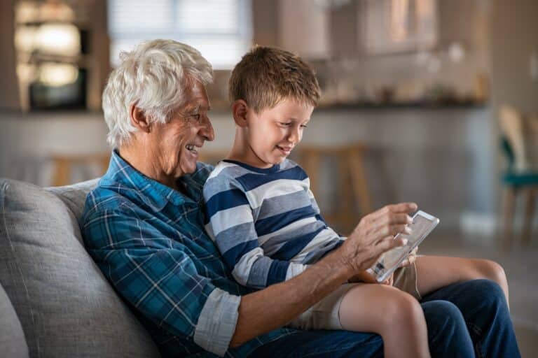 Athene Annuity Review Grandfather and grandchild using digital tablet together