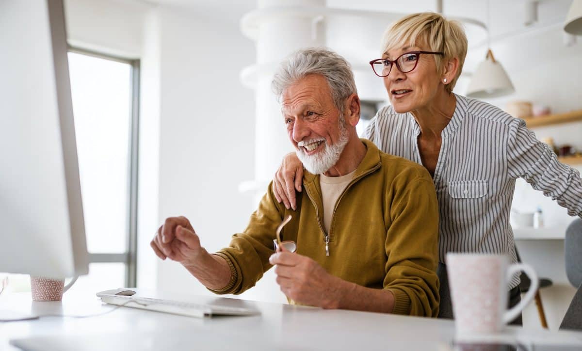 An older couple looking at computer together.