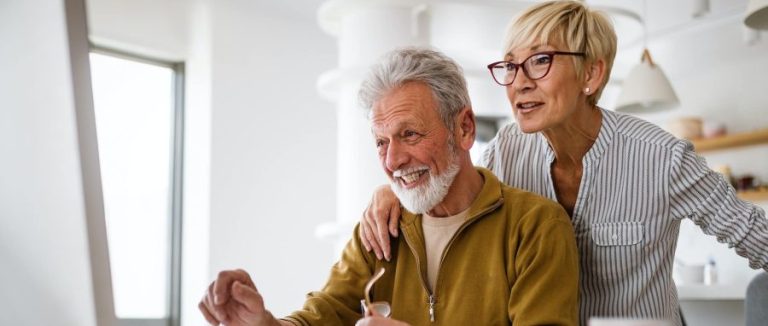 An older couple looking at computer together.