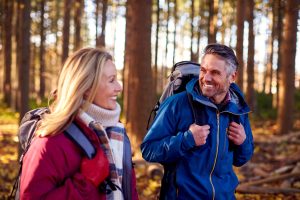 Retirement aged man and woman backpacking during the fall.