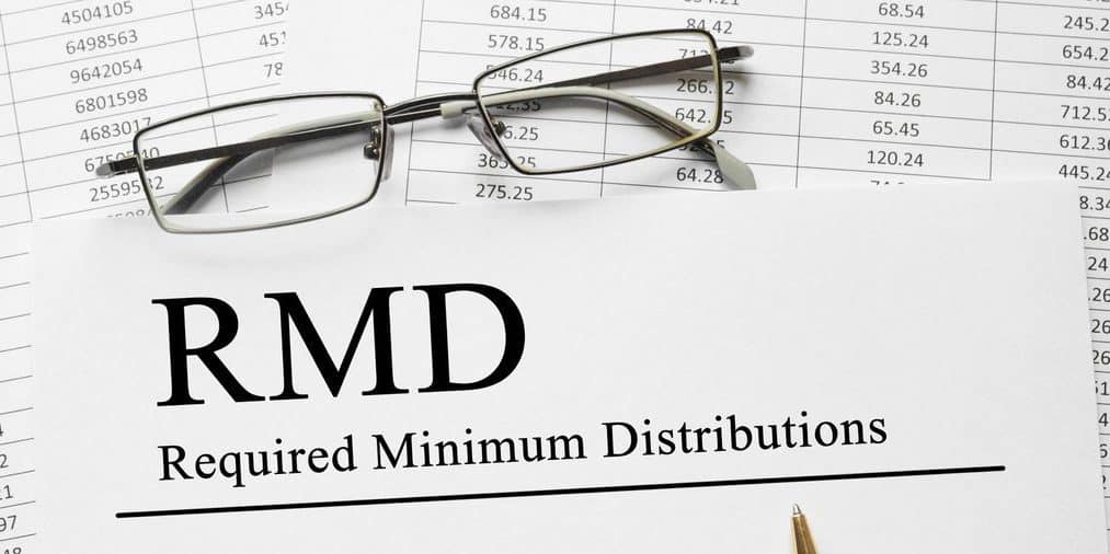 59 1/2 r and rmd withdrawal rules - rmd in bold letters on paper with spreadsheet in background.